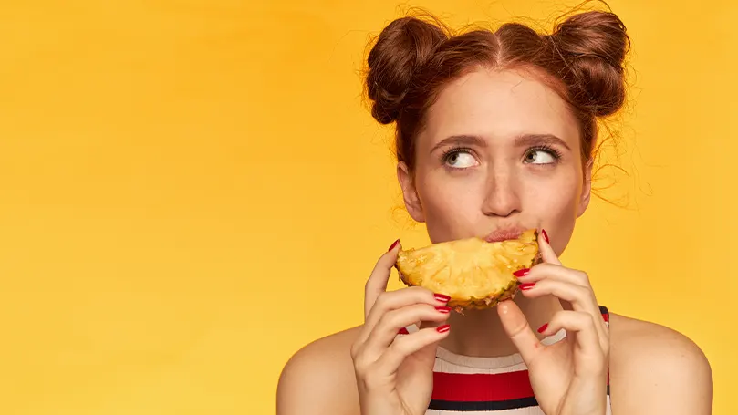 Image d'une femme mangeant un ananas