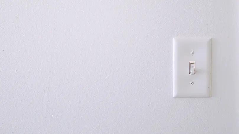 Image d'un interrupteur sur un mur blanc