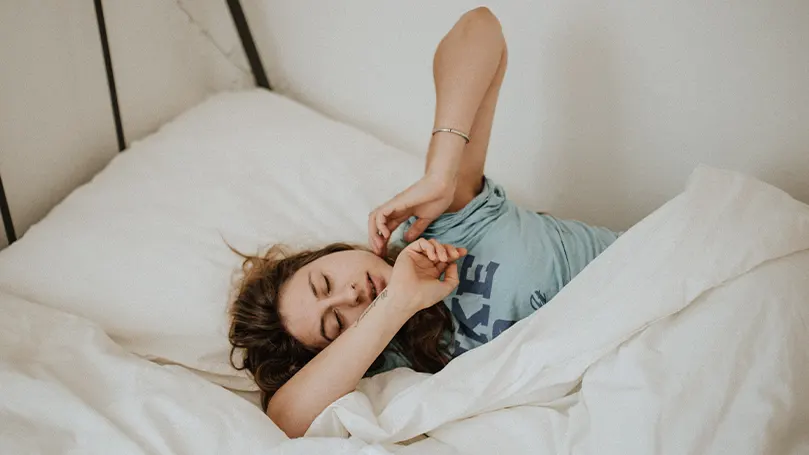 Image d'une femme au lit essayant de s'endormir