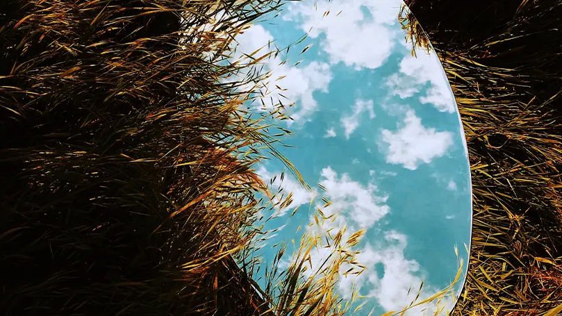 Image d'un miroir posé sur le sol et reflétant le ciel