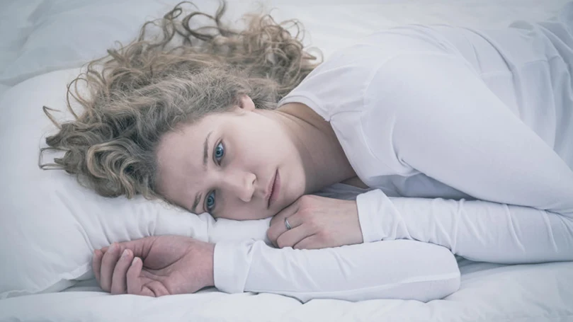 l'image d'une femme déprimée allongée dans un lit