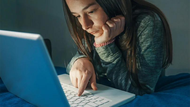 une image d'une fille travaillant sur un ordinateur la nuit