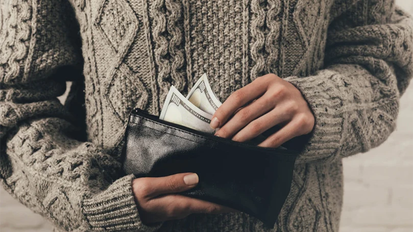 un homme tenant un portefeuille avec de l'argent