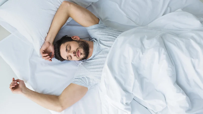 une image d'un homme dormant dans un lit