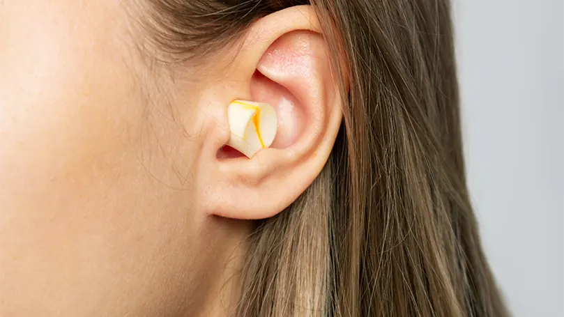Image d'une femme portant des bouchons d'oreille.