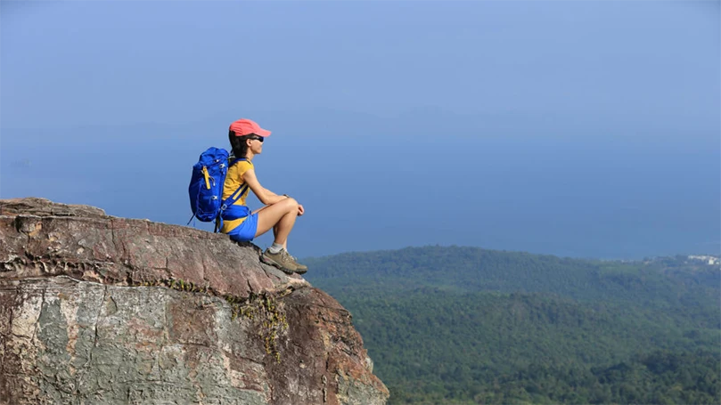 une femme assise sur le bord d'un rocher