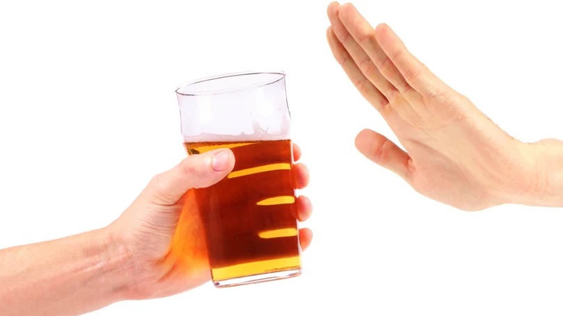 Une main qui refuse de prendre un verre d'alcool