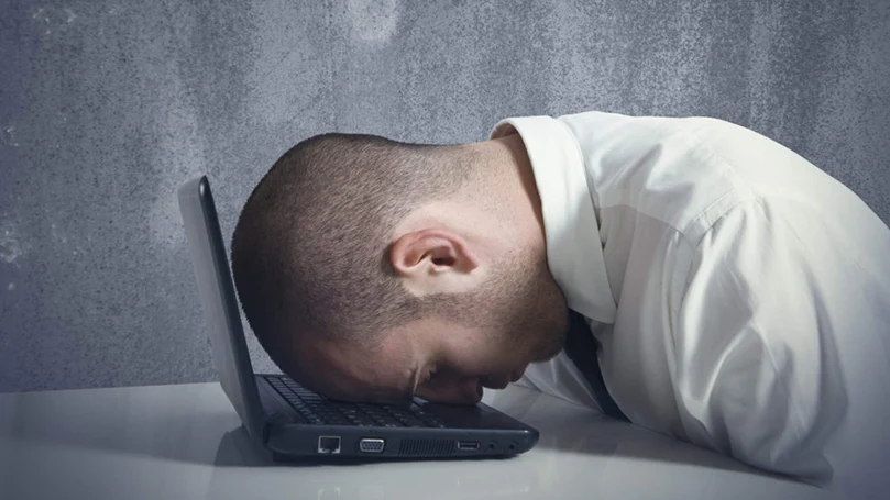 une image d'un homme dormant sur un ordinateur portable