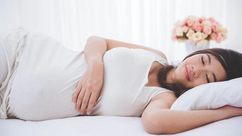 une image d'une femme enceinte dormant sur le côté
