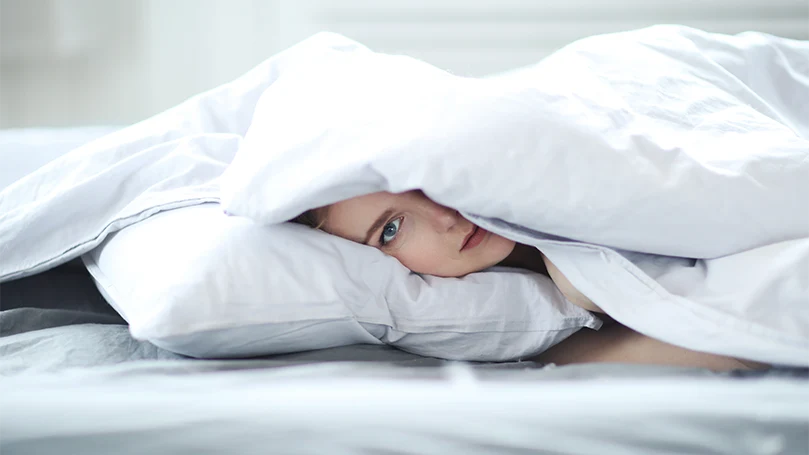 l'image d'une femme allongée dans un lit recouvert d'une couette