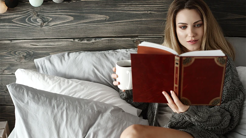 Image d'une femme lisant un livre au lit