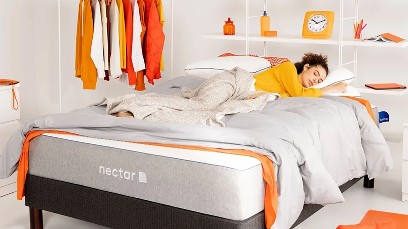 l'image d'une femme allongée sur un matelas hybride au nectar dans une chambre à coucher