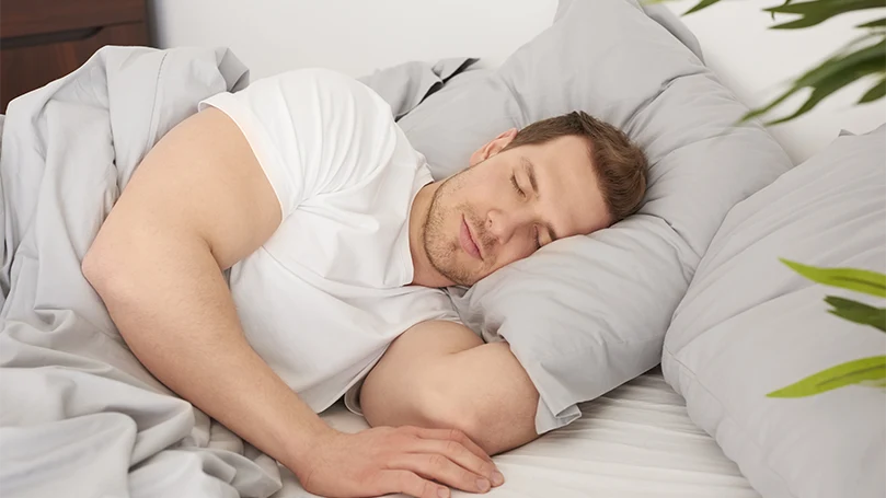 un homme dormant confortablement dans son lit