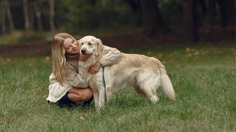 une image d'une femme serrant un chien dans ses bras