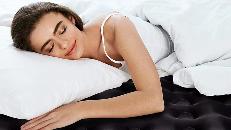 une image d'une femme dormant sur un matelas pneumatique