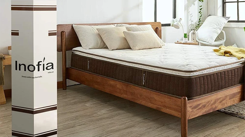 Matelas hybride Inofia sur un cadre de lit en bois dans une chambre à coucher.