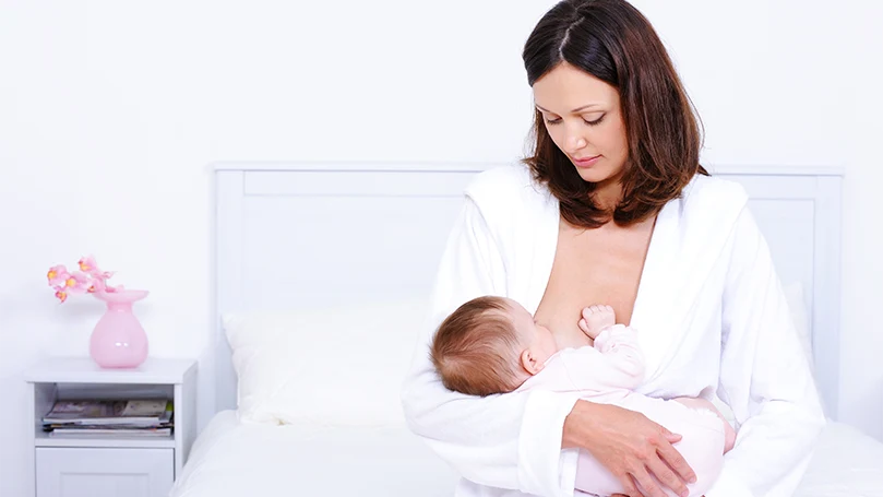 une image d'une femme allaitant son bébé
