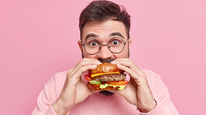 Image d'un homme mangeant un hamburger.