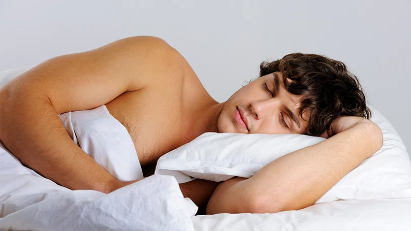 Image d'un jeune homme dormant sur le côté.