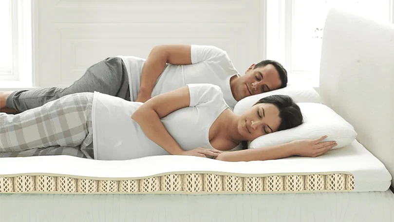 Image d'un couple dormant sur le surmatelas Dormeo Octaspring Classic.