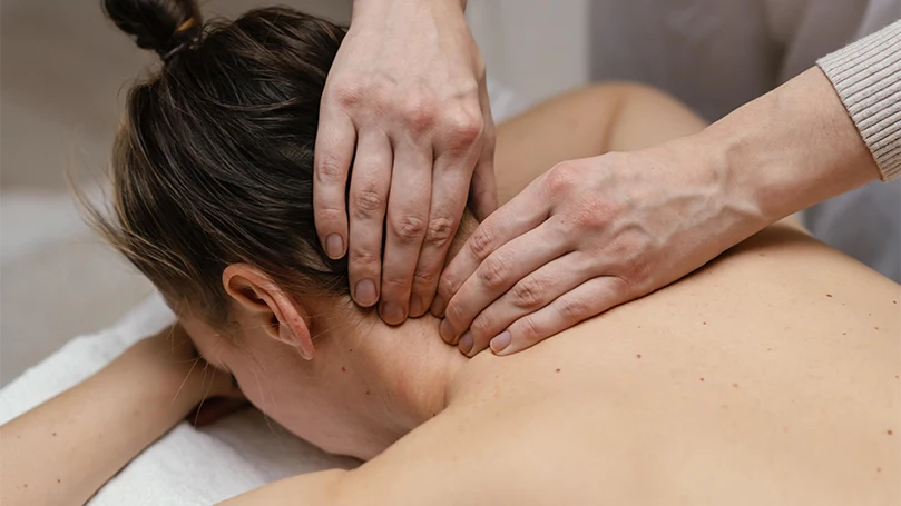 Image d'un thérapeute massant le cou d'une femme.