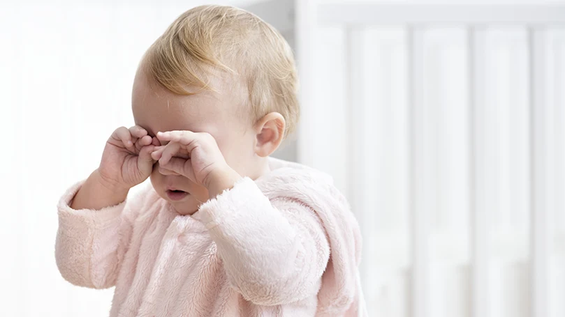 Image d'un bébé se frottant les yeux