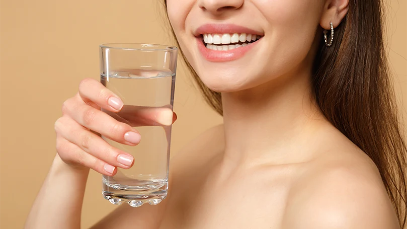 Image d'une femme tenant un verre d'eau.