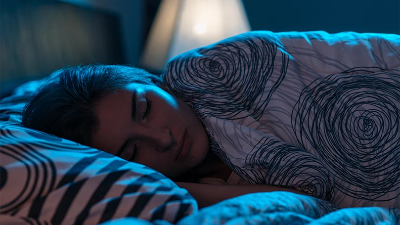 Image d'une jeune femme dormant dans son lit sans paralysie du sommeil.