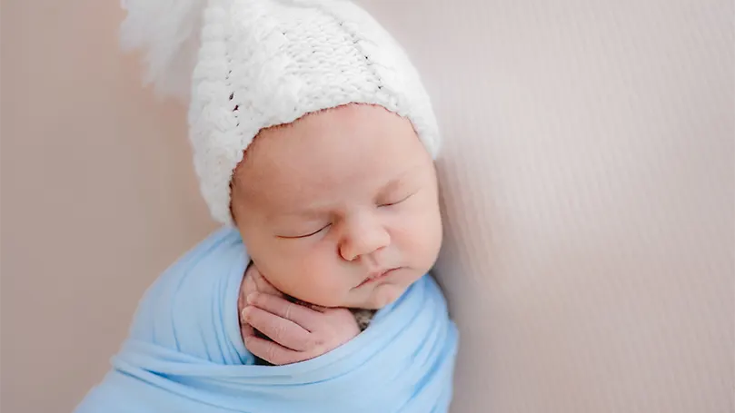 Image d'un bébé portant un chapeau pendant son sommeil.