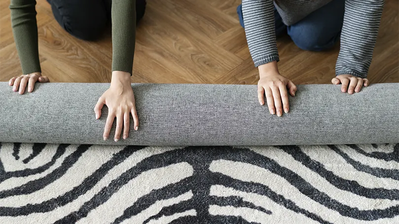 Un couple met un tapis sous le lit pour éviter qu'il ne glisse.