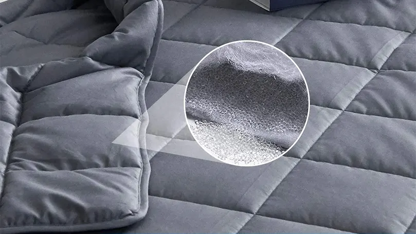 Image en gros plan d'une couverture lestée remplie de billes de verre.