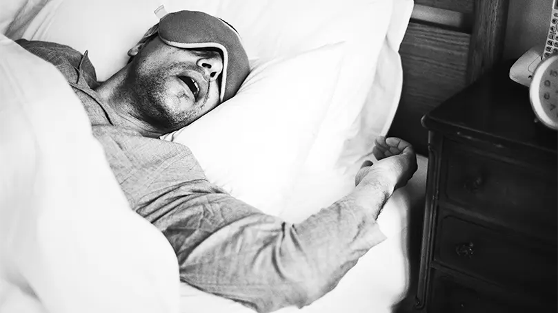 Image d'un homme qui dort et ronfle.