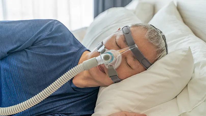 Un homme âgé dormant avec un masque CPAP