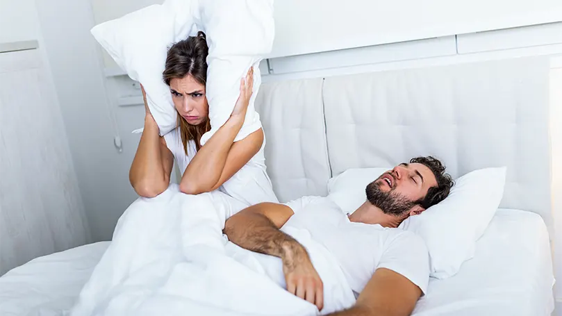 Une femme ne peut pas dormir à cause d'un homme qui ronfle dans le lit pendant qu'elle dort