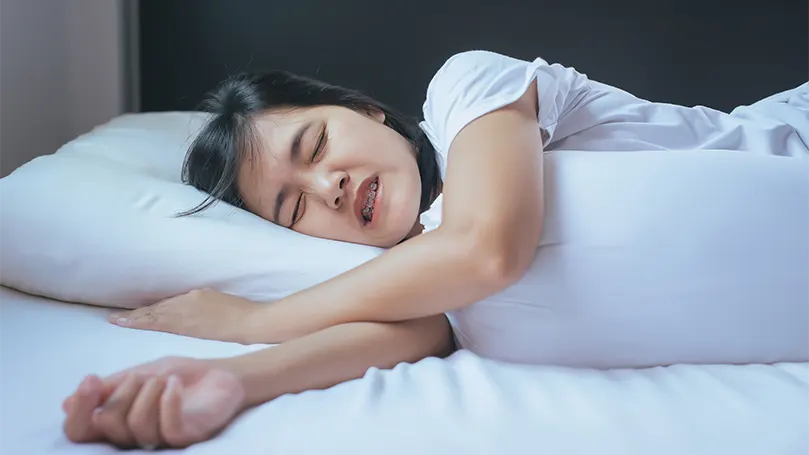 Image d'une femme souffrant de bruxisme pendant son sommeil.