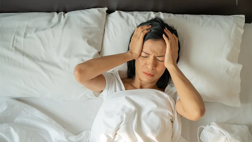 Une femme au lit souffrant de vertiges pendant son sommeil.