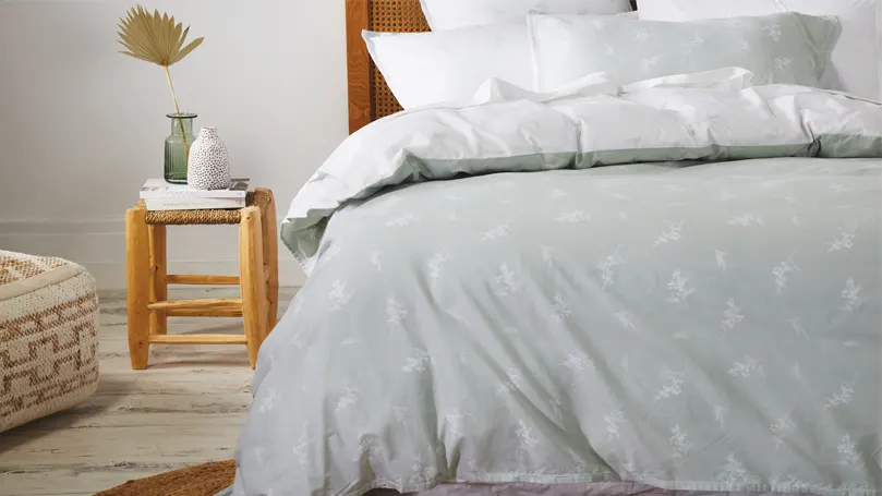 Image d'une literie grise sur un lit.