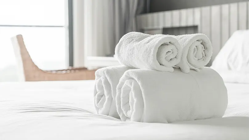 Une image de 2 serviettes blanches en coton égyptien sur un lit.