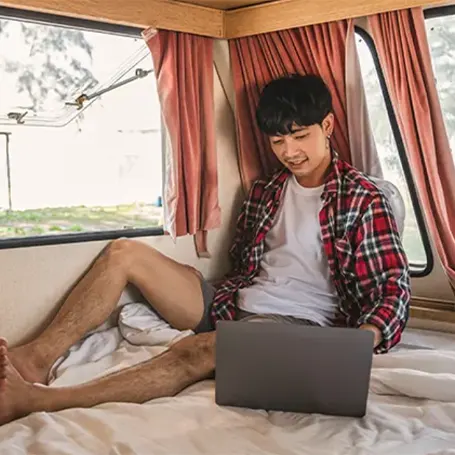 Un homme avec un ordinateur portable dans un camping-car
