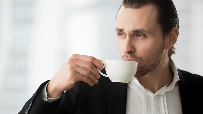 Image d'un homme buvant un café et rêvant.