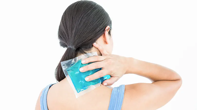 Image d'une femme mettant une poche de glace sur son cou