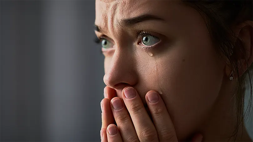 Image d'une femme triste aux yeux verts qui pleure.