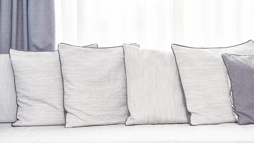 Image d'oreillers et de literie sur un canapé.