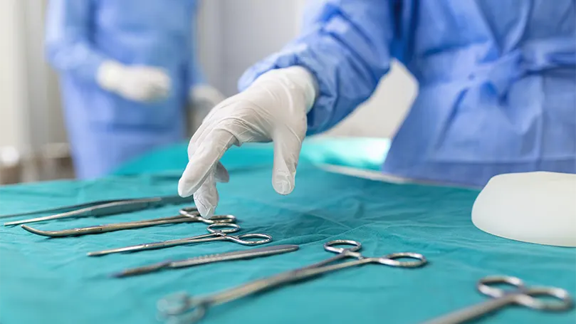 Image d'une infirmière prenant un instrument chirurgical.