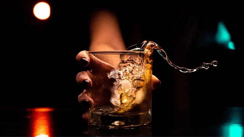 Image d'une personne tenant un verre d'alcool