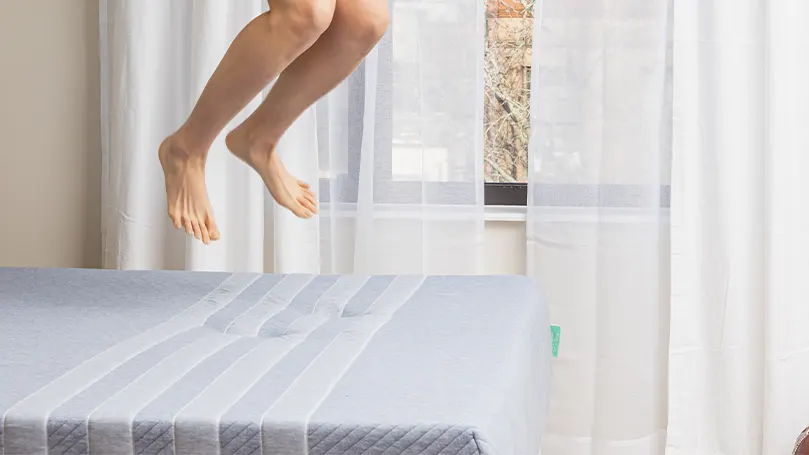 Image d'une personne sautant sur un lit