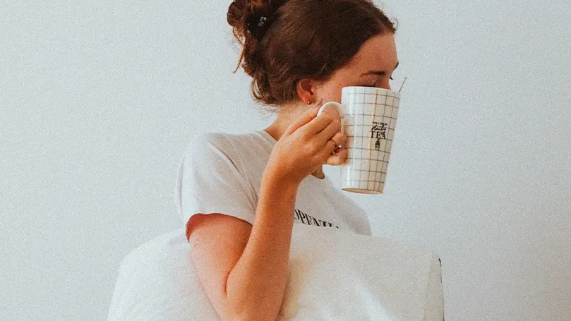 Image d'une femme se réveillant de son sommeil et buvant du thé dans le cadre de sa routine matinale.