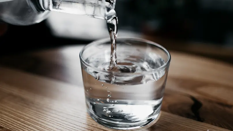 Image d'une personne versant de l'eau dans une tasse