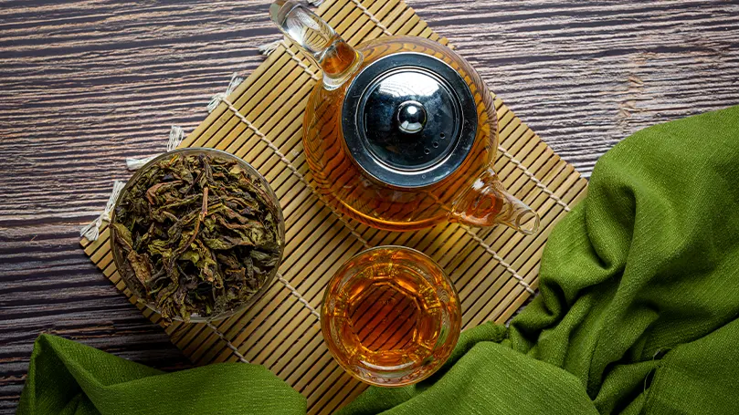 Image d'un thé oolong dans une théière posée sur une table.
