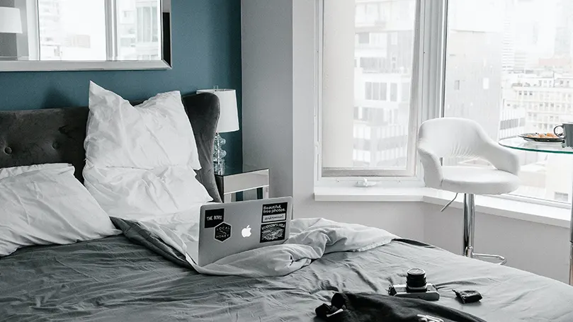 Une image de Un bon soutien avec des oreillers pour travailler depuis le lit.